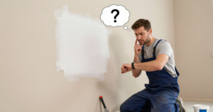contractor thinking in front of spackled wall